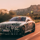 A photo of a camouflage Rolls Royce Spectre driving on a highway.